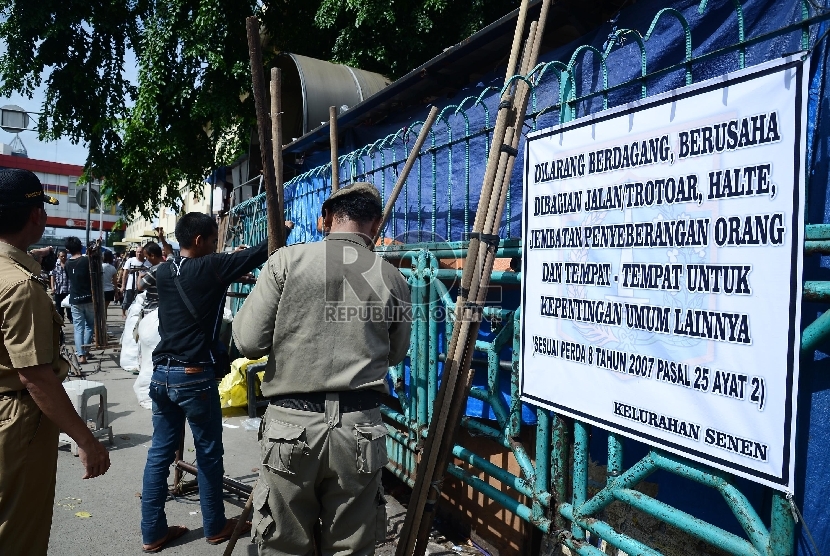 Petugas Satpol PP menertibkan pedagang di trotoar Pasar Senen, Jakarta Pusat, Rabu (21/1). ( Republika/Raisan Al Farisi)