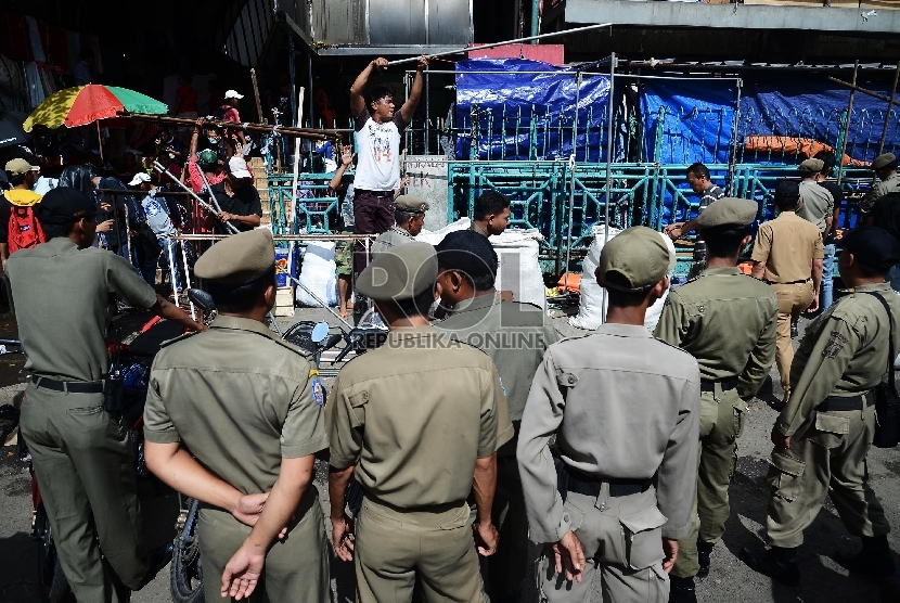 Petugas Satpol PP menertibkan pedagang di trotoar Pasar Senen, Jakarta Pusat, Rabu (21/1). ( Republika/Raisan Al Farisi)