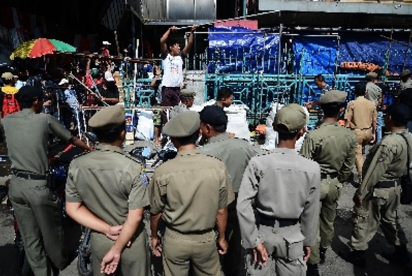 Petugas Satpol PP menertibkan pedagang di trotoar Pasar Senen, Jakarta Pusat, Rabu (21/1).