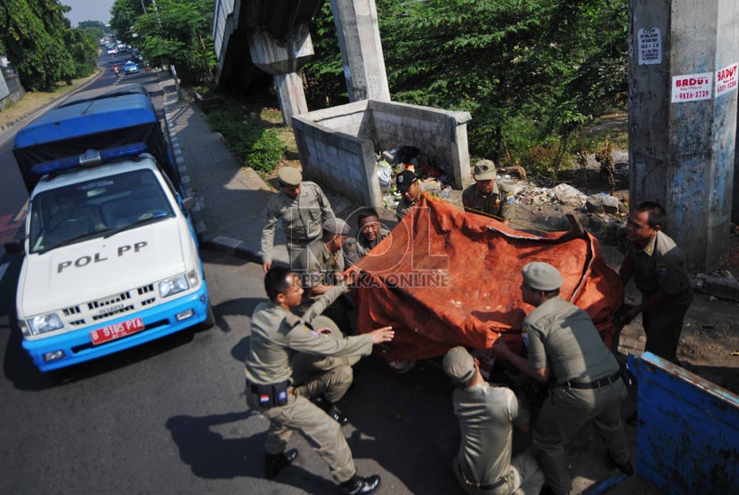  Petugas Satpol PP mengangkut gerobak saat melaksanakan penertiban pedagang kaki lima di kawasan Ciracas, Jakarta Timur, Rabu (17/9). (Republika/Rakhmawaty La'lang)