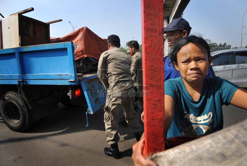  Petugas Satpol PP mengangkut gerobak saat melaksanakan penertiban pedagang kaki lima di kawasan Ciracas, Jakarta Timur, Rabu (17/9). (Republika/Rakhmawaty La'lang)