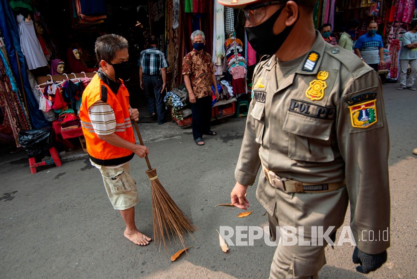 Petugas Satpol PP mengawasi pelanggar aturan pembatasan sosial berskala besar (PSBB) yang melaksanakan sanksi kerja sosial  (ilustrasi)