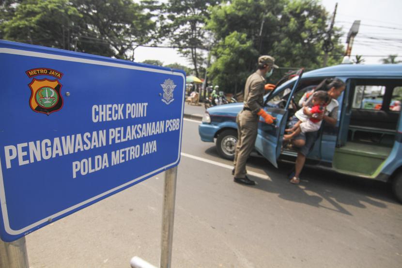 Petugas Satpol PP menghentikan angkot yang tidak mengikuti aturan PSBB saat memasuki kawasan Jakarta di Jalan Raya Bogor, Jakarta Timur, Jumat (10/4/2020). Pengawasan di perbatasan Jakarta dengan Kota Depok tersebut dalam rangka penerapan Pembatasan Sosial Berskala Besar (PSBB) di Kota Depok.