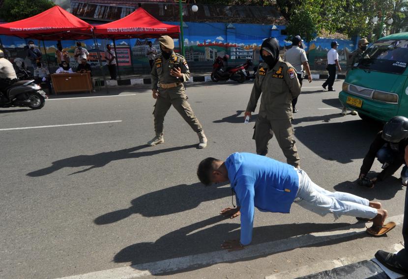 Petugas Satpol PP menghukum seorang pria dengan push up karena tidak menggunakan masker. Masih banyak warga di Bandung yang tak memakai masker saat keluar rumah. Ilustrasi.