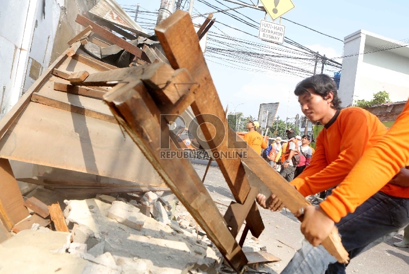 Petugas Satpol PP saat membongkar salah satu dari puluhan kios pedagang di Jalan Bunga, Pal Meriam, Jakarta, Rabu (29/7).   (Republika/Yasin Habibi)