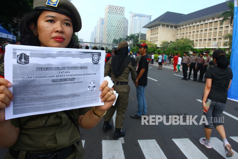 Petugas Satpol PP wanita mensosialisasikan Pergub tentang larangan melakukan kegiatan politik diacara dan tempat berlangsungnya Hari Bebas Kendaraan Bermotor atau Car Free Day (CFD) di Jakarta, Ahad (6/5).