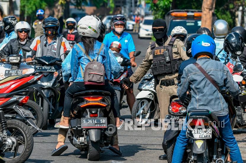 Petugas Satuan Polisi Pamong Praja (Satpol PP) mengarahkan pengendara sepeda motor untuk mengikuti tes usap (swab test) COVID-19 di kawasan Pasar Keputran, Surabaya, Jawa Timur.