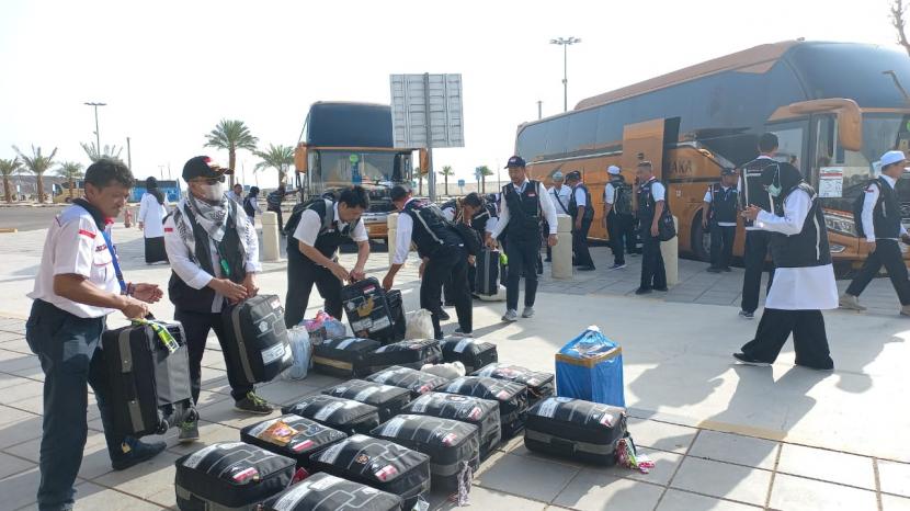 Petugas sedang estafet menurunkan barang bawaan jamaah haji embarkasi Solo (SOC 43) di Bandar Udara Internasional Pangeran Muhammad bin Abdulazis, Sabtu (13/8/2022). Kemenag Buka Seleksi Petugas Haji 2023