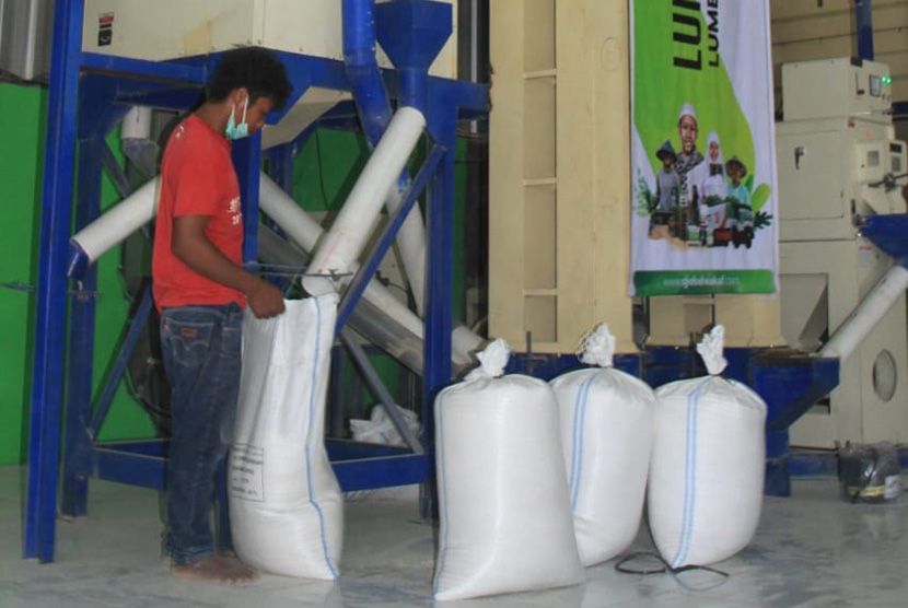 Petugas sedang melakukan proses pengepakan beras di Lumbung Beras Wakaf ACT.