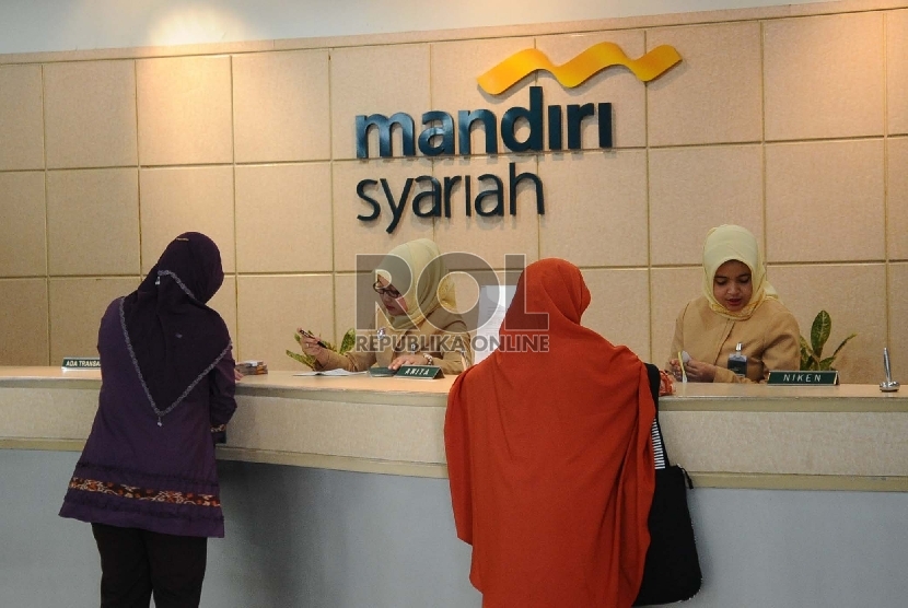  Petugas sedang melayani nasabah di kantor Bank Syariah Mandiri (BSM), Jakarta, Selasa (22/12).