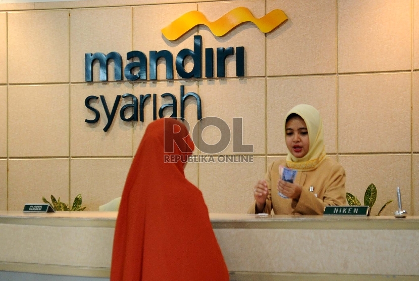 Petugas sedang melayani nasabah di kantor Bank Syariah Mandiri (BSM), Jakarta, Selasa (22/12). 