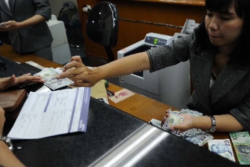  Petugas sedang melayani penukaran uang di Jakarta, Selasa (25/8).