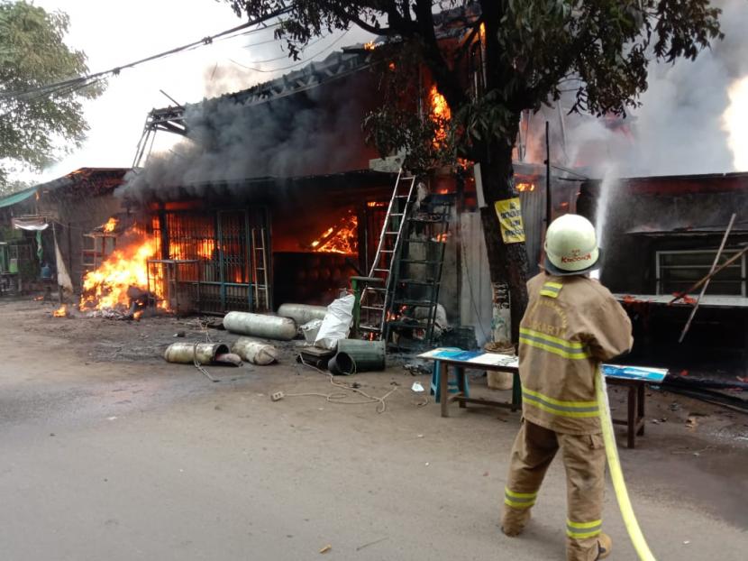 Petugas sedang memadamkan api yang membakar enam bangunan di Jalan Komarudin, Cakung, Jakarta Timur, Selasa (9/3) pagi. Kebakara itu terjadi karena letupan api dari sebuah bengkel las. 