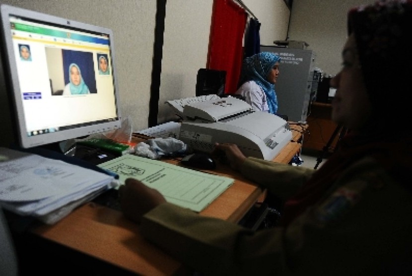 Petugas sedang memfoto dalam pembuatan e-KTP di Kelurahan Cikoko, Pancoran, Jakarta Selatan, Rabu (27/11).