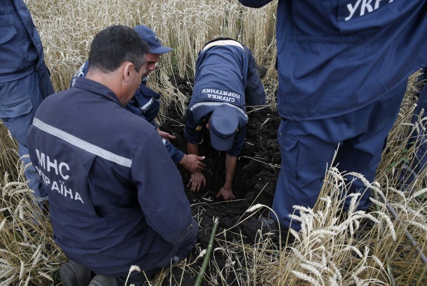 Petugas sedang mencari tubuh korban pesawat Malaysia Airlines MH17 yang jatuh karena diduga ditembak