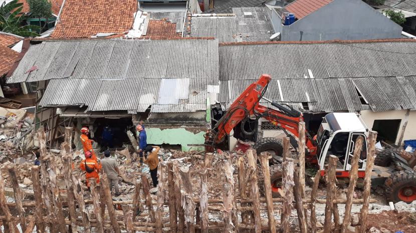Petugas sedang mengangkat reruntuhan tebing yang menutup badan sungai di Jalan Damai RT 04/RW 02, Kelurahan Ciganjur, Jagakarsa, Jakarta Selatan, pada Senin (12/10). Turap kayu juga mulai dipasang di tebing itu guna mencegah longsor susulan.