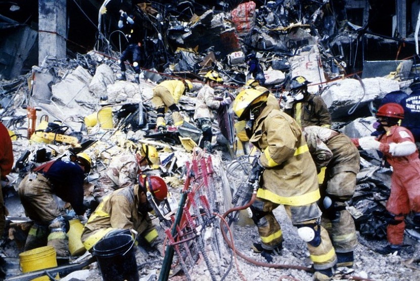 Petugas sedang mengevakuasi korban ledakan bom truk di luar Gedung Federal Alfred P Murrah di Oklahoma City, Negara Bagian Oklahoma, Amerika Serikat (AS). Peristiwa ledakan bom truk ini terjadi pada 19 April 1995 silam.