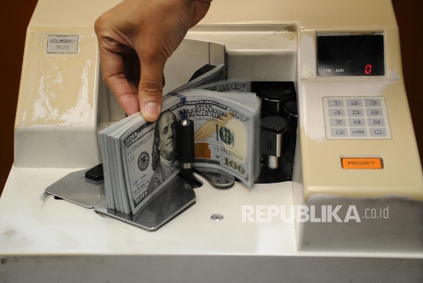 Petugas sedang menghitung mata uang dolar pada penukaran uang di Jakarta, Selasa (7/6).  (Republika/Tahta Aidilla)