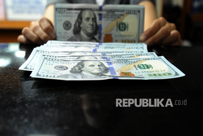 Petugas sedang menghitung mata uang dolar pada penukaran uang di Jakarta.  (Republika/Tahta Aidilla)