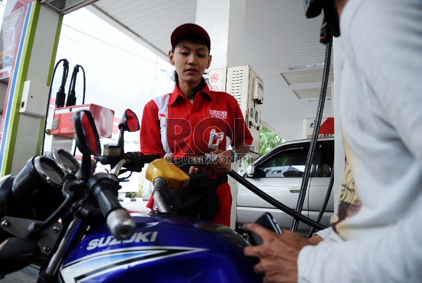 Petugas sedang mengisi BBM pada kendaraan di Stasiun Pengisian Bensin Umum (SPBU), Jakarta, Senin (5/10). 