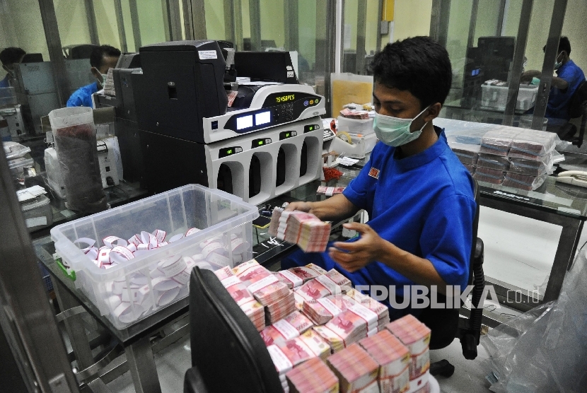  Petugas sedang menyusun tumpukan uang rupiah di Cash Center Bank BNI, Jakarta, Kamis (8\12). 