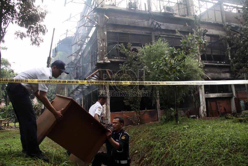  Petugas sekuriti menyelamatkan barang usai peristiwa kebakaran di Gedung C FISIP Universitas Indonesia, Depok, Jawa Barat, Selasa (7/1).   (Republika/Yasin Habibi)