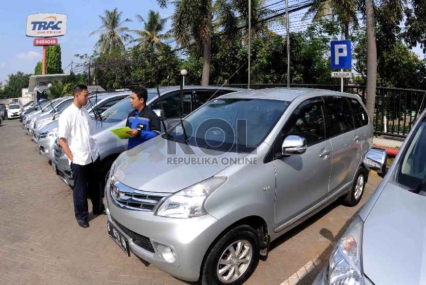 Petugas sewa mobil (kanan) memberika keterangan kepada calon penyewa terkait kondisi kendaraan sebelum digunakan di penyewaan mobil Trac (Astra Rent A Car), Jakarta, Jumat (10/7).