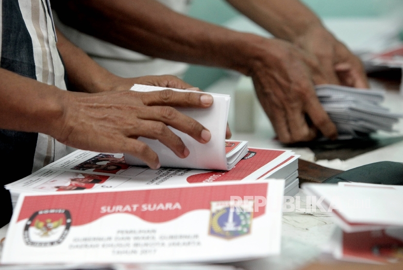 Petugas sortir dan lipat menyelesaikan pelipatan surat suara 