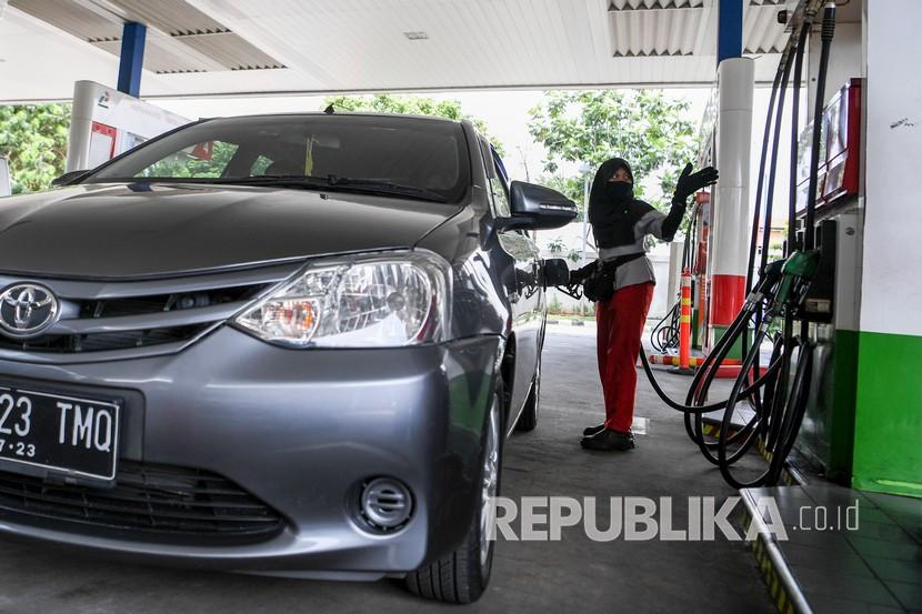 Petugas SPBU Lilis Setiawati (24) mengisi bahan bakar sebuah mobil di Jakarta. Sejumlah warga masih melakukan aktivitas kerja di luar rumah seperti biasanya meski di saat pandemi COVID-19 agar tetap memberikan pelayanan kepada warga. 