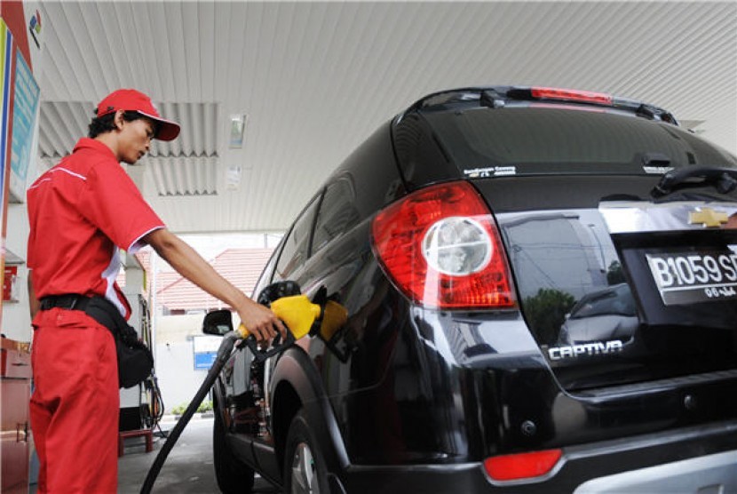 Petugas SPBU mengisikan bahan bakar minyak (BBM) bersubsidi atau premium pada mobil mewah di sebuah stasiun pengisian BBM umum (SPBU) di Cikini, Jakarta, Senin (2/4). 