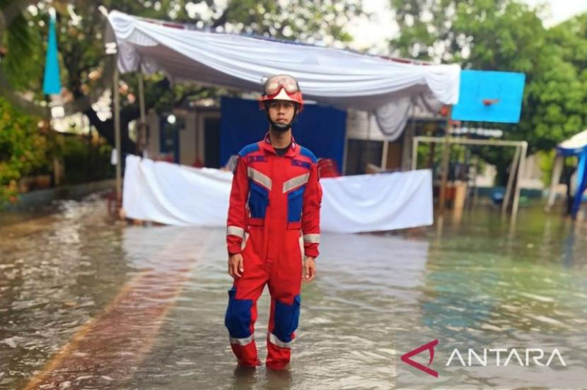 Petugas Sudin Penanggulangan Kebakaran dan Penyelamatan (Gulkarmat) Jakarta Timur tengah mengecek ketinggian air di TPS yang terendam banjir di Rawamangun, Kecamatan Pulogadung,.Jakarta Timur, Rabu (14/2/2024).
