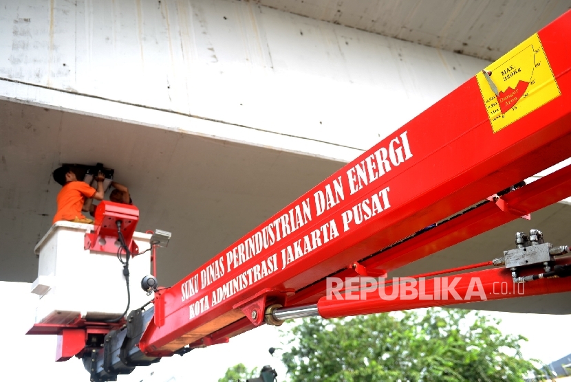 Petugas Sudin Perindustrian dan Energi Jakpus mengganti lampu penerangan di bawah jalan layang Suprapto, Jakarta Pusat, Selasa (19/7).  (Republika/ Wihdan)