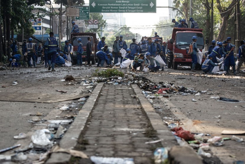 Petugas Sudin Sumber Daya Air membersihkan jalan pascakerusuhan di kawasan Kantor Bawaslu, Jakarta, Kamis (23/5).