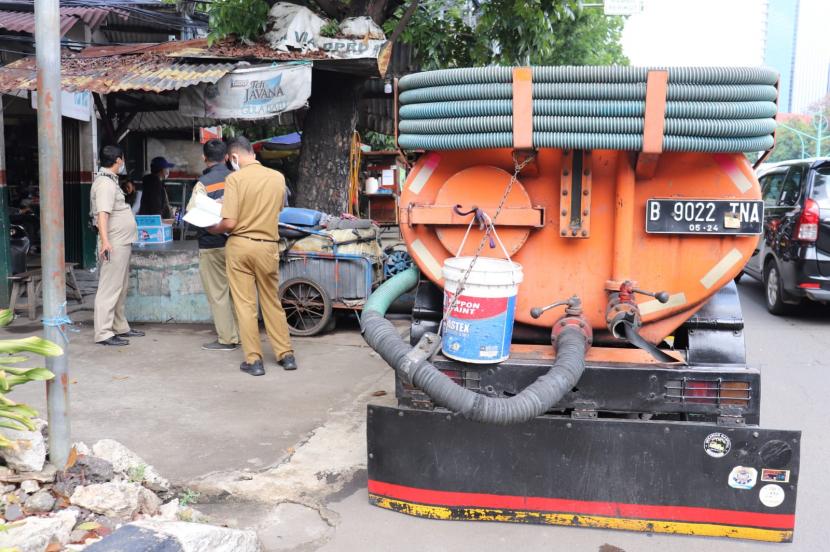 Petugas Suku Dinas Lingkungan Hidup Jakarta Selatan sedang menindak operator truk sedot WC yang tertangkap basah sedang buang limbah tinja di saluran air warga di Mampang Prapatan.