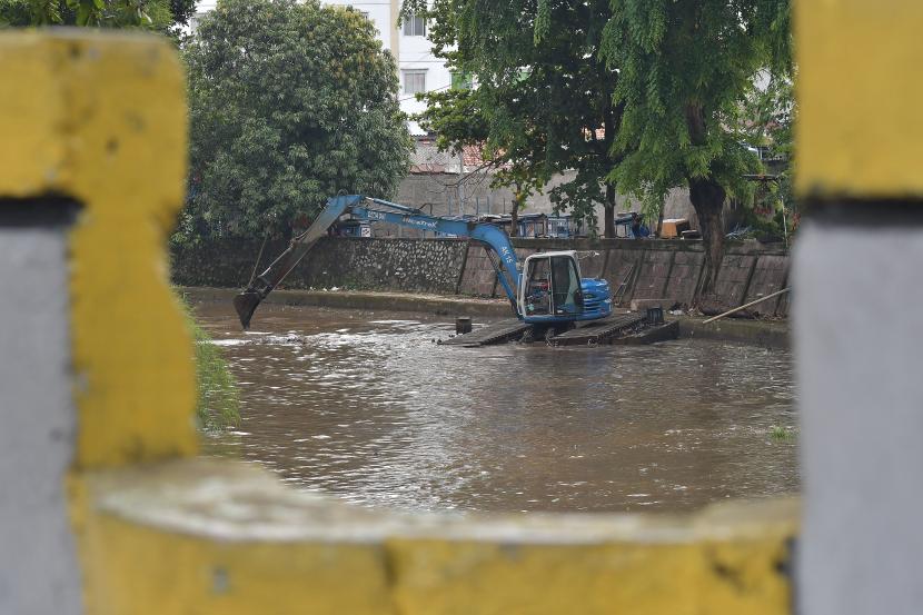 Petugas Sumber Daya Air (SDA) menggunakan alat berat mengeruk lumpur di aliran Kali Ciliwung, Gambir, Jakarta Pusat, Sabtu (8/10/2022). Menurut petugas pengerukan lumpur untuk mecegah pendangkalan kali dan banjir saat musim hujan.
