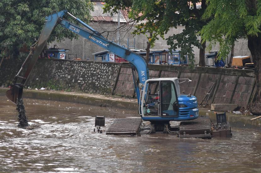 Petugas Sumber Daya Air (SDA) menggunakan alat berat mengeruk lumpur di aliran Kali Ciliwung, Gambir, Jakarta Pusat, ilustrasi
