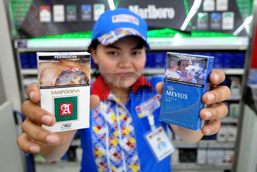 Petugas supermarket menunjukan sejumlah rokok yang sudah dilengkapi peringatan bergambar akan bahaya merokok di Jakarta, Senin (23/6).