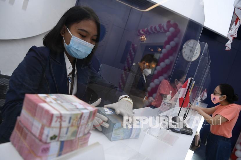 Petugas teller menghitung pecahan rupiah di Bank Mandiri Cabang Jakarta Sudirman, Jakarta, Senin (23/8). Rupiah dibuka melemah 7 poin atau 0,05 persen ke posisi Rp 14.255 per dolar AS