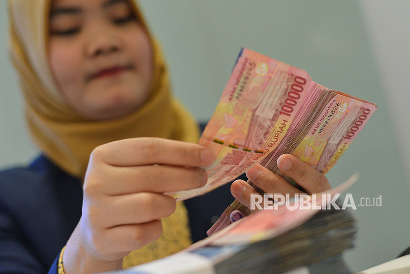 Petugas teller menghitung pecahan uang rupiah di Kantor Pusat Bank Mandiri, Kamis (28/6). 