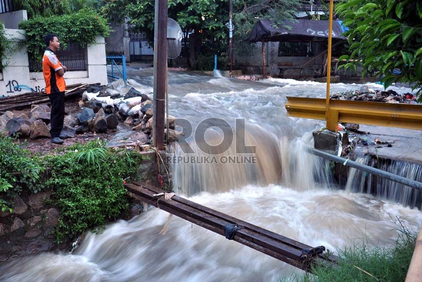  Petugas tengah memperhatikan arus air akibat jebolnya tanggul Kali Laya di perumahan Bukit Cengkeh II, Depok, Jawa Barat, Selasa (13/11). (Rakhmawaty La'lang)