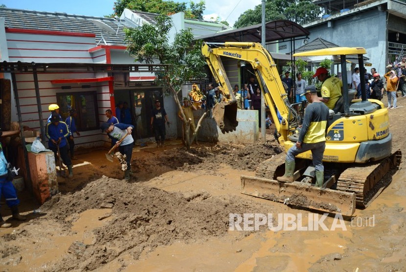 Petugas terkait, aparat dan relawan bersama warga membersihkan material sisa banjir bandang yang melanda Komplek Jati Endah Regency, Pasirjati, Cilengkrang, Kabupaten Bandung, Senin (11/2).