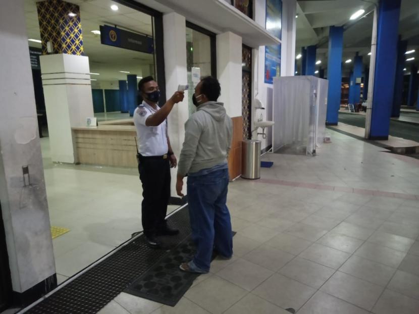 Petugas Terminal Tipe A Tirtonadi di Kota Solo melakukan pengecekan suhu badan para penumpang dan kru bus menggunakan termometer tembak (thermo gun).