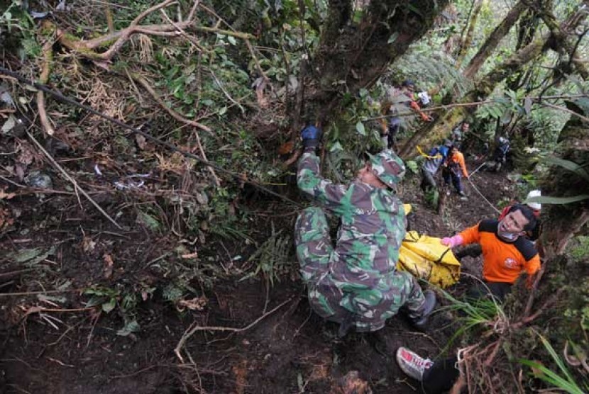 Petugas TNI dan sejumlah relawan mengevakuasi korban jatuhnya pesawat Sukhoi Superjet 100 ke Puncak I Gunung Salak, Kabupaten Bogor, Jawa Barat, Ahad (13/5).
