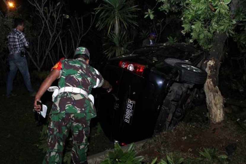 Petugas TNI melihat mobil anggota polisi yang terbalik di TKP penembakan polisi di Graha Raya, Pondok Aren, Tangerang Selatan, Jumat (16/8). 