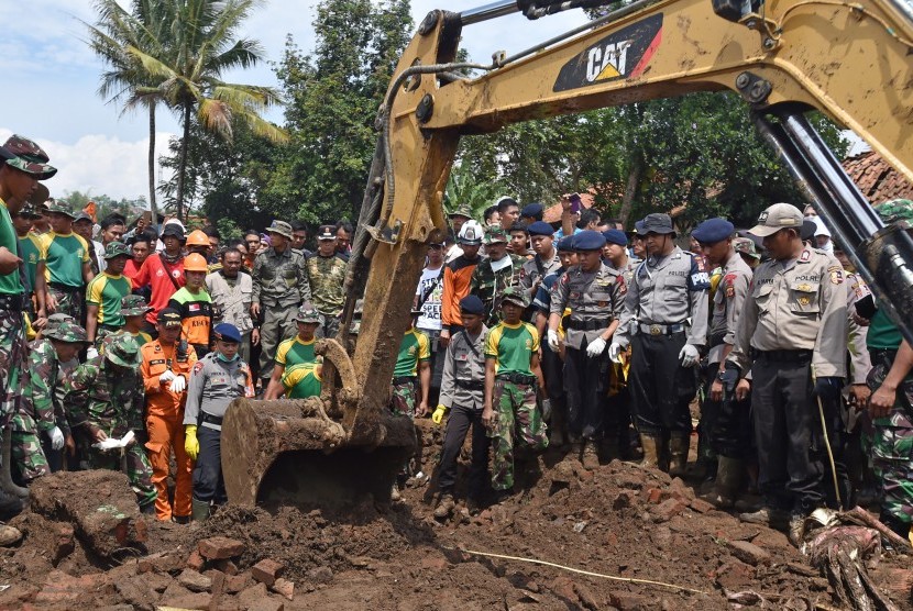 Petugas TNI, Polri, serta Basarnas dibantu alat berat mencari korban banjir bandang pascaluapan aliran Sungai Cimanuk di Lapangparis, Tarogong Kidul, Kabupaten Garut, Jabar, Jumat (23/9).