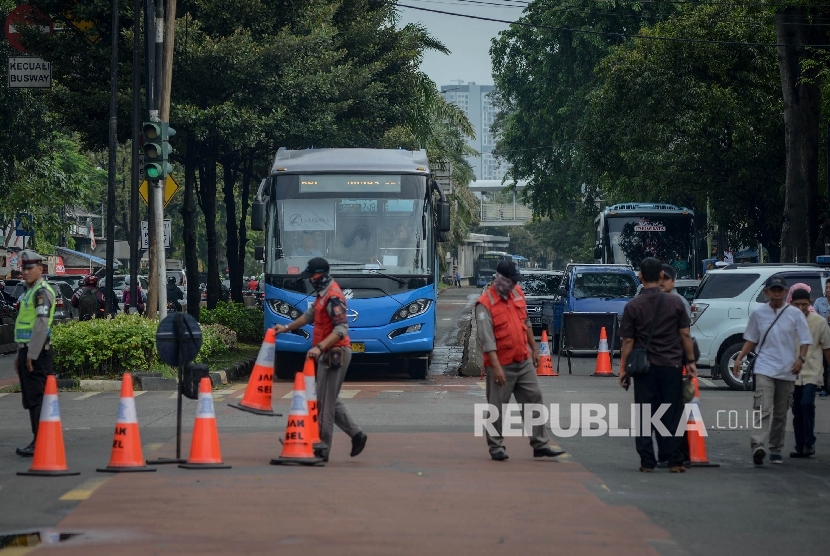 Petugas Transjakarta membuka jalan untuk busway saat pengalihan arus di perempatan Ragunan, Jakarta Selatan, Selasa (10/1).
