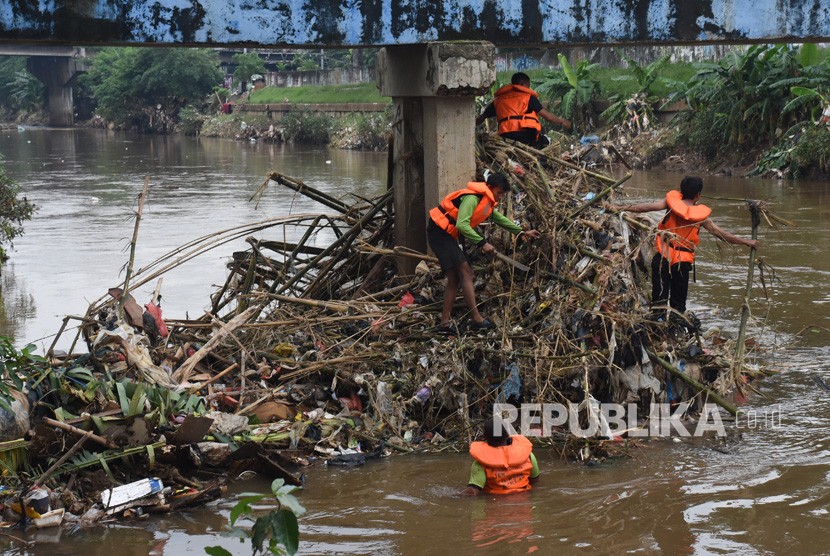 Petugas UPK Badan Air Dinas Lingkungan Hidup DKI Jakarta membersihkan sampah yang tersangkut di aliran Kanal Banjir Barat Ciliwung, Jakarta, Rabu (8/1/2020).