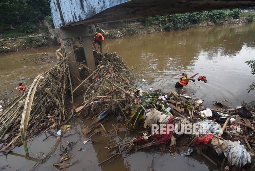 Petugas UPK Badan Air Dinas Lingkungan Hidup DKI Jakarta membersihkan sampah yang tersangkut di aliran Kanal Banjir Barat Ciliwung, Jakarta, Rabu (8/1/2020). 
