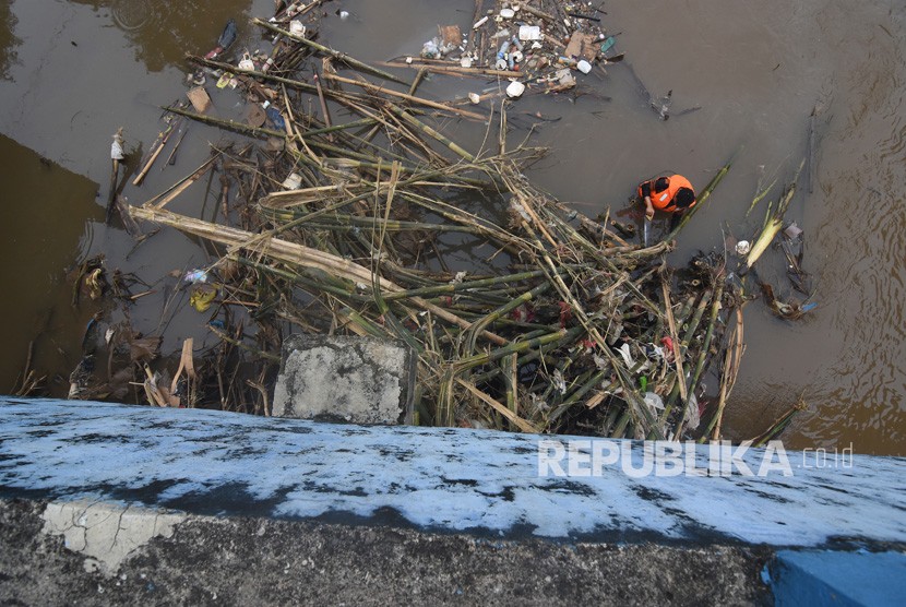 Petugas UPK Badan Air Dinas Lingkungan Hidup DKI Jakarta membersihkan sampah yang tersangkut di aliran Kanal Banjir Barat Ciliwung, Jakarta, Rabu (8/1/2020). 