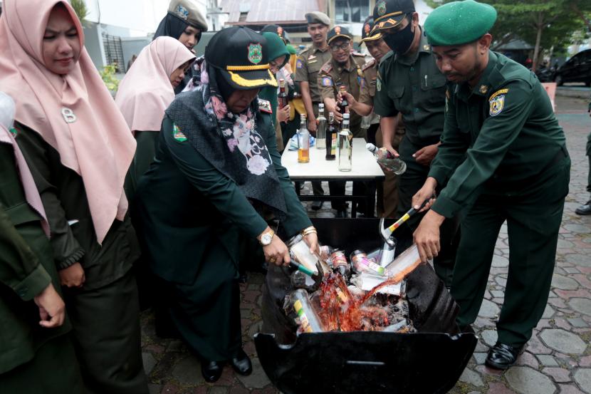 Petugas Wilayatul Hisbah atau Polisi Syariat Islam Kota Banda Aceh memusnahkan berbagai jenis barang bukti minuman keras (miras) hasil sitaan di Banda Aceh, Aceh, Selasa (27/9/2022). Satuan Polisi Pamong Praja dan Wilyatul Hisbah (Satpol PP dan WH) Kota Banda Aceh memusnahkan puluhan botol barang bukti minuman keras yang disita dari pelanggar peraturan daerah (Qanun) Aceh Nomor 6/2014 tentang Hukum Jinayat. 